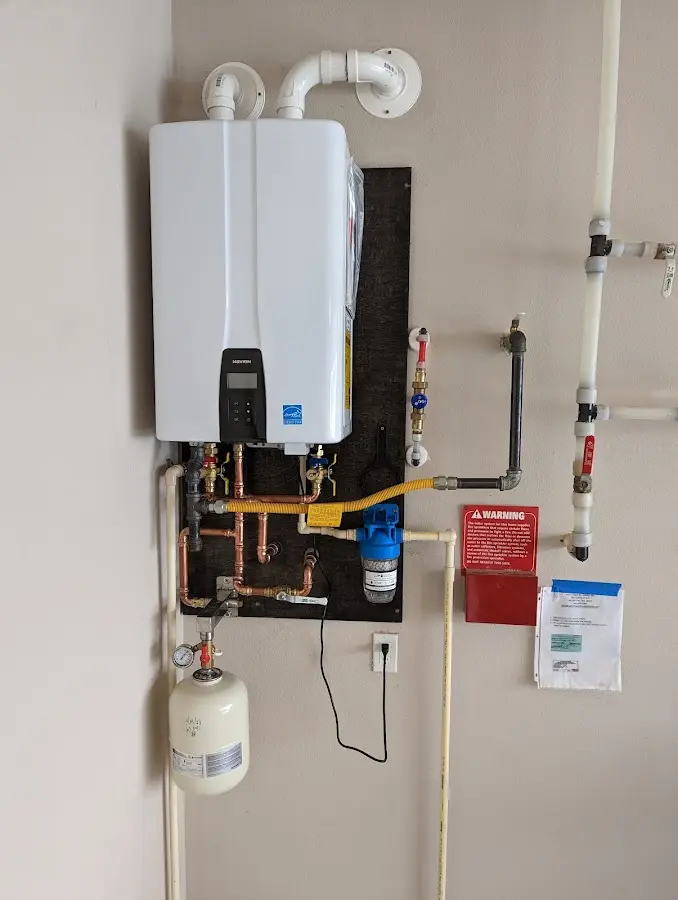 Professional plumber installing copper piping in a Millington home